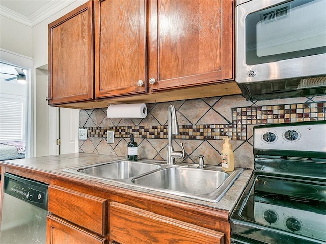 1122 NW 42nd St, Oklahoma City, OK 73118 - kitchen with appliances with stainless steel finishes, ornamental molding, brown cabinetry, and tasteful backsplash
