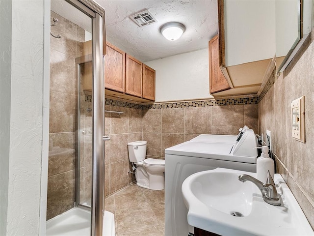 1122 NW 42nd St, Oklahoma City, OK 73118 - full bath featuring washing machine and dryer, a stall shower, and tile walls