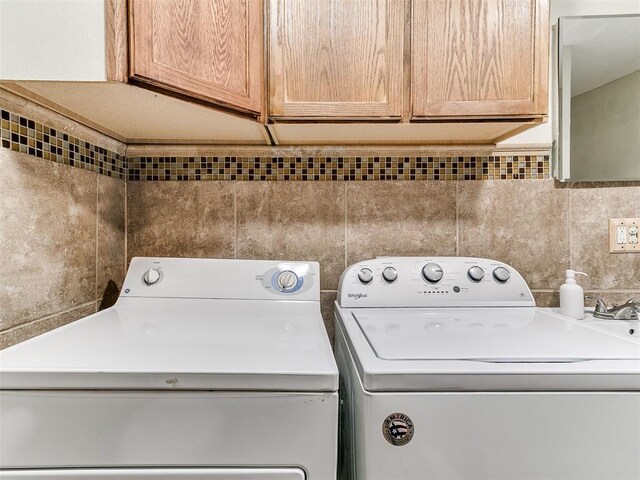 1122 NW 42nd St, Oklahoma City, OK 73118 - washroom featuring independent washer and dryer, cabinet space, and tile walls
