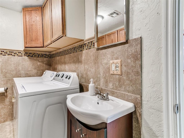 1122 NW 42nd St, Oklahoma City, OK 73118 - washroom featuring separate washer and dryer, tile walls, and a textured wall