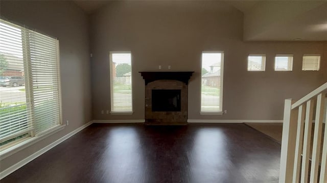 11321 NW 102nd St, Yukon, OK 73099 - unfurnished living room with dark wood-type flooring, healthy amount of natural light, and a fireplace with raised hearth