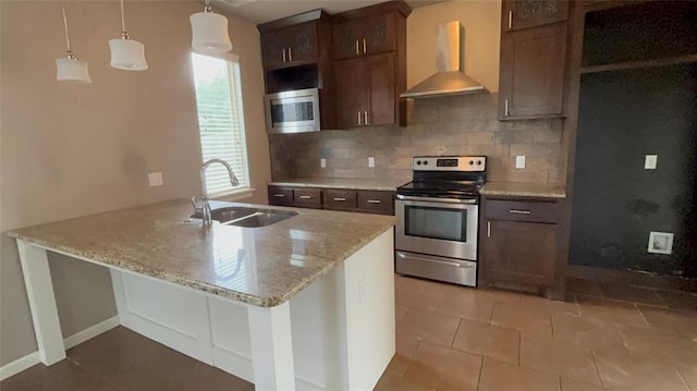11321 NW 102nd St, Yukon, OK 73099 - kitchen with wall chimney exhaust hood, stainless steel appliances, tasteful backsplash, a peninsula, and light stone counters