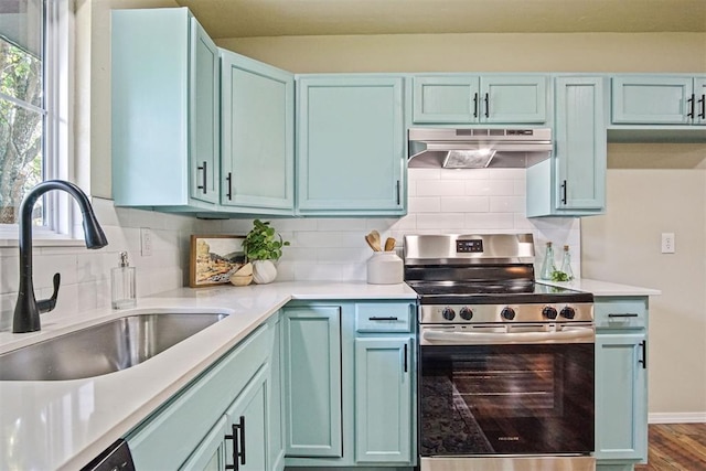 102078 S 3480th Rd, Meeker, OK 74855 - kitchen featuring electric range, under cabinet range hood, tasteful backsplash, light countertops, and blue cabinets