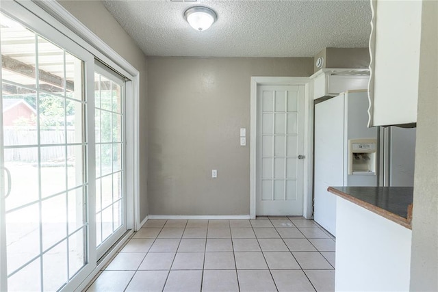 1512 SW 77th Ter, Oklahoma City, OK 73159 - unfurnished dining area featuring a textured ceiling and light tile patterned flooring