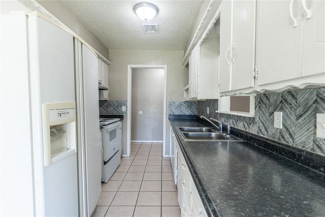 1512 SW 77th Ter, Oklahoma City, OK 73159 - kitchen featuring white appliances, white cabinets, decorative backsplash, a textured ceiling, and dark countertops