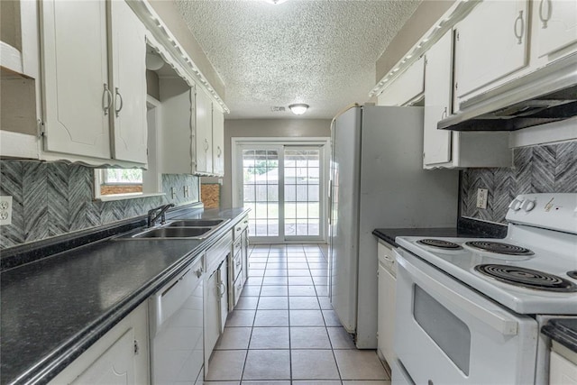 1512 SW 77th Ter, Oklahoma City, OK 73159 - kitchen with white appliances, a textured ceiling, dark countertops, white cabinetry, and under cabinet range hood