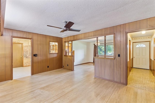 13722 NE 9th St, Choctaw, OK 73020 - unfurnished room featuring light wood-type flooring, wooden walls, ceiling fan, and a textured ceiling