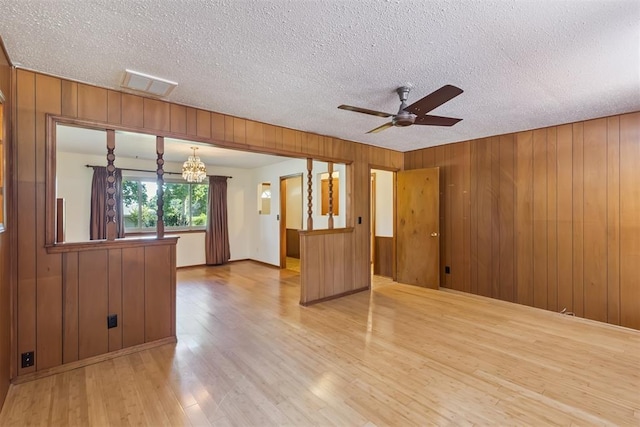 13722 NE 9th St, Choctaw, OK 73020 - unfurnished room featuring wood finished floors, a ceiling fan, wood walls, a chandelier, and a textured ceiling
