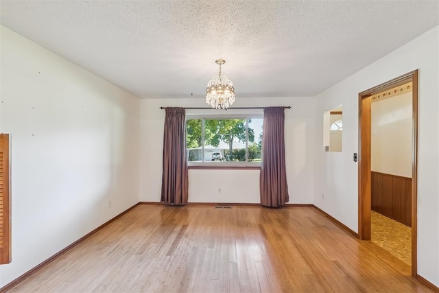 13722 NE 9th St, Choctaw, OK 73020 - empty room featuring light wood-style floors, a chandelier, and a textured ceiling
