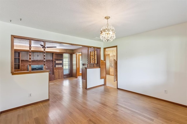 13722 NE 9th St, Choctaw, OK 73020 - unfurnished living room featuring a chandelier, wood finished floors, and a textured ceiling