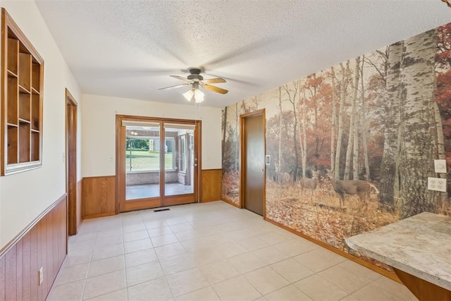 13722 NE 9th St, Choctaw, OK 73020 - empty room with wainscoting, a textured ceiling, ceiling fan, wooden walls, and wallpapered walls