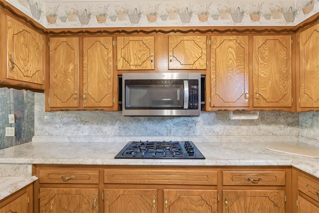 13722 NE 9th St, Choctaw, OK 73020 - kitchen with stainless steel microwave, black gas stovetop, and light countertops