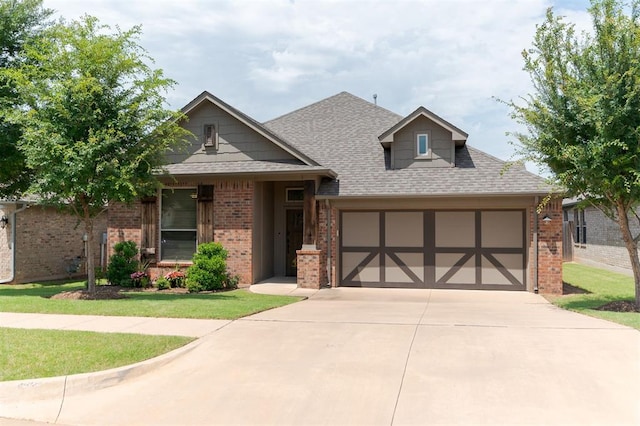 13 Ivory Dr, Yukon, OK 73099 - view of front of property featuring brick siding, a garage, concrete driveway, a front yard, and roof with shingles