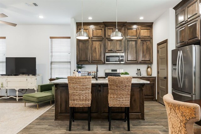 13 Ivory Dr, Yukon, OK 73099 - kitchen with appliances with stainless steel finishes, dark brown cabinetry, dark wood-type flooring, decorative light fixtures, and recessed lighting