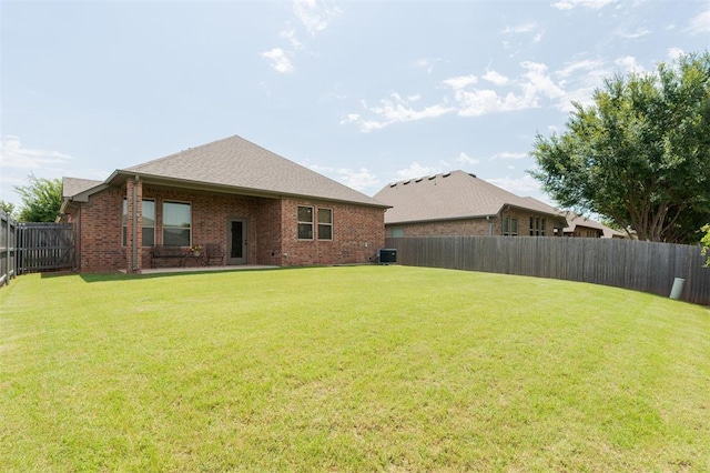 13 Ivory Dr, Yukon, OK 73099 - back of house featuring brick siding, a fenced backyard, and roof with shingles