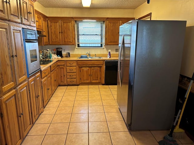 5612 NW 65th St, Warr Acres, OK 73132 - kitchen featuring black appliances, backsplash, brown cabinets, and a textured ceiling