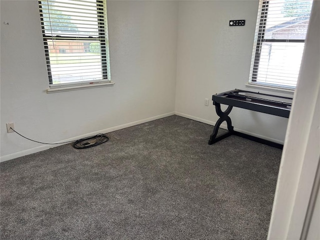 5612 NW 65th St, Warr Acres, OK 73132 - empty room with dark colored carpet and healthy amount of natural light