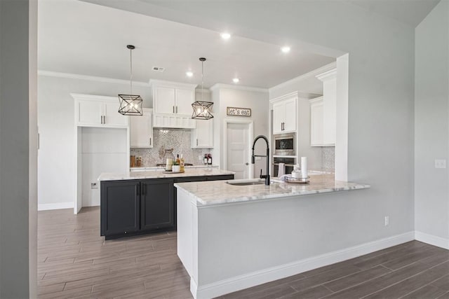 12825 SW 26th St, Yukon, OK 73099 - kitchen with backsplash, dark wood-style floors, white cabinets, ornamental molding, and recessed lighting
