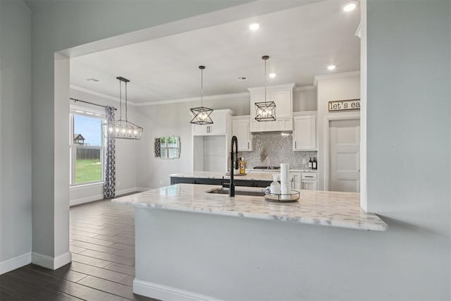 12825 SW 26th St, Yukon, OK 73099 - kitchen featuring white cabinets, dark wood finished floors, decorative backsplash, light stone counters, and pendant lighting