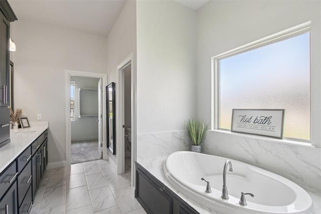 12825 SW 26th St, Yukon, OK 73099 - bathroom featuring vanity, plenty of natural light, a bath, and marble look tile flooring