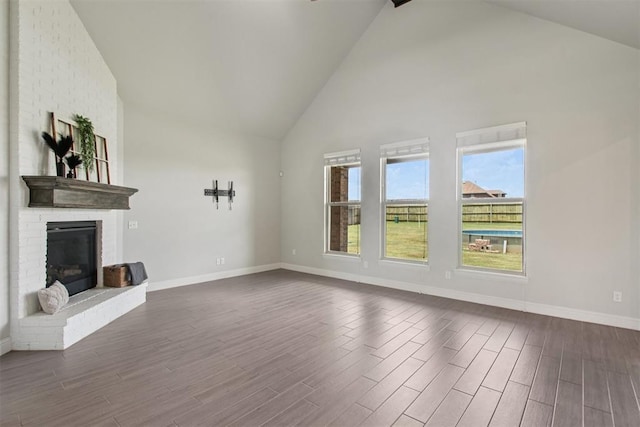 12825 SW 26th St, Yukon, OK 73099 - unfurnished living room featuring high vaulted ceiling, dark wood-style floors, and a fireplace