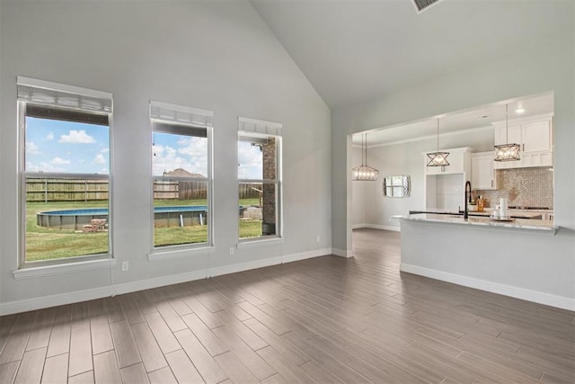 12825 SW 26th St, Yukon, OK 73099 - unfurnished living room with high vaulted ceiling, plenty of natural light, and dark wood-style floors