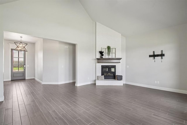 12825 SW 26th St, Yukon, OK 73099 - unfurnished living room featuring high vaulted ceiling, dark wood finished floors, a chandelier, and a fireplace