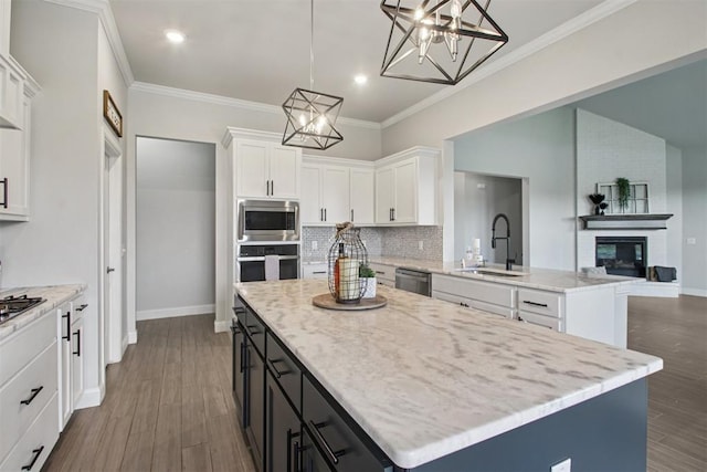 12825 SW 26th St, Yukon, OK 73099 - kitchen with a center island, white cabinets, a chandelier, decorative backsplash, and ornamental molding