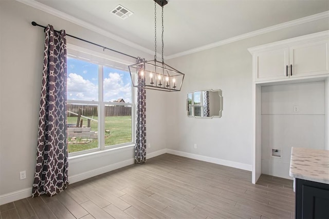 12825 SW 26th St, Yukon, OK 73099 - unfurnished dining area featuring a chandelier, wood finished floors, plenty of natural light, and crown molding