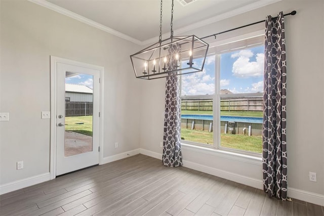 12825 SW 26th St, Yukon, OK 73099 - unfurnished dining area featuring a chandelier, ornamental molding, wood finished floors, and plenty of natural light