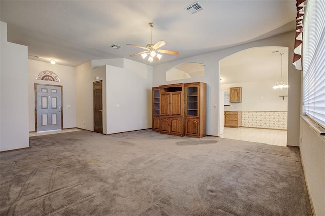2401 Westchester Dr, Moore, OK 73160 - unfurnished living room featuring carpet floors, a ceiling fan, arched walkways, and a chandelier