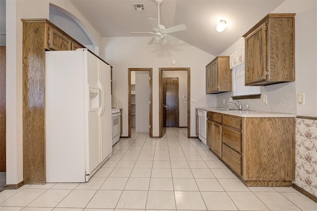 2401 Westchester Dr, Moore, OK 73160 - kitchen with white appliances, lofted ceiling, light countertops, ceiling fan, and brown cabinets