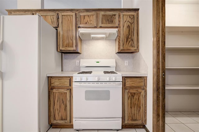 2401 Westchester Dr, Moore, OK 73160 - kitchen featuring white appliances, under cabinet range hood, light countertops, and light tile patterned flooring
