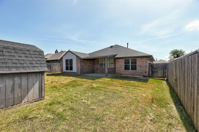 2401 Westchester Dr, Moore, OK 73160 - rear view of house with brick siding, a fenced backyard, a storage unit, a patio, and roof with shingles