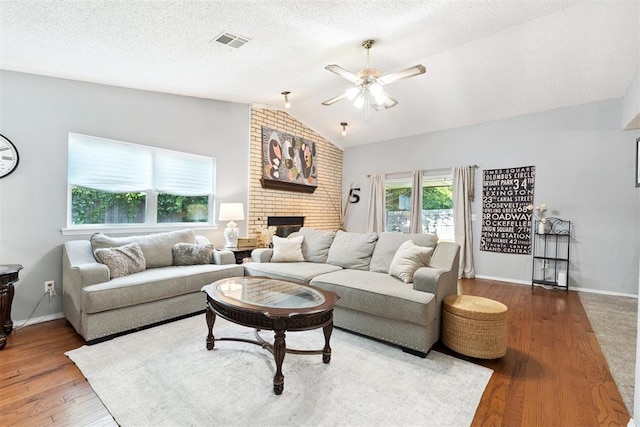 815 W 7th St, Edmond, OK 73003 - living area with lofted ceiling, ceiling fan, a fireplace, and wood finished floors