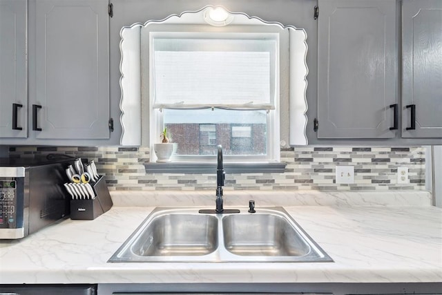 815 W 7th St, Edmond, OK 73003 - kitchen with gray cabinets, backsplash, and light stone countertops