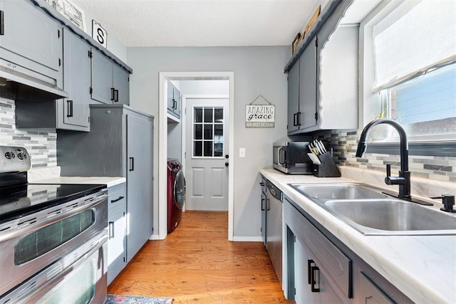 815 W 7th St, Edmond, OK 73003 - kitchen featuring stainless steel appliances, washer / clothes dryer, light wood-style flooring, light countertops, and gray cabinets