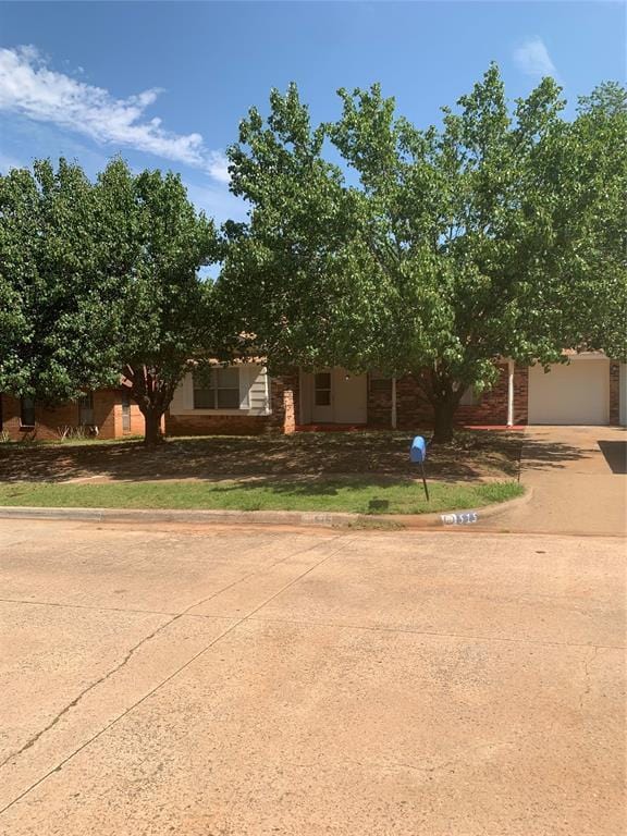 515 Cripple Creek Dr, Norman, OK 73071 - obstructed view of property with concrete driveway and brick siding