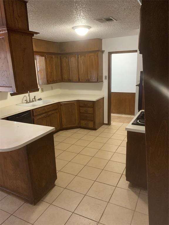 515 Cripple Creek Dr, Norman, OK 73071 - kitchen featuring a peninsula, light countertops, a textured ceiling, light tile patterned flooring, and black electric cooktop