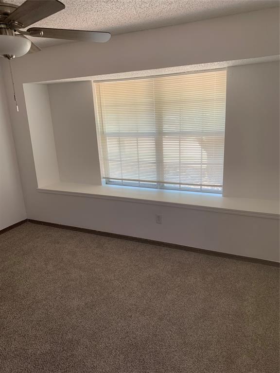 515 Cripple Creek Dr, Norman, OK 73071 - carpeted empty room featuring ceiling fan and a textured ceiling