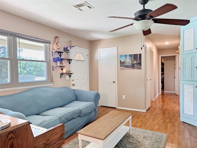 2901 Maple Ln, Edmond, OK 73034 - living area featuring a ceiling fan, light wood-style floors, and a textured ceiling