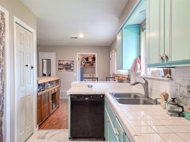 2901 Maple Ln, Edmond, OK 73034 - kitchen with dishwasher, tile counters, a peninsula, and backsplash