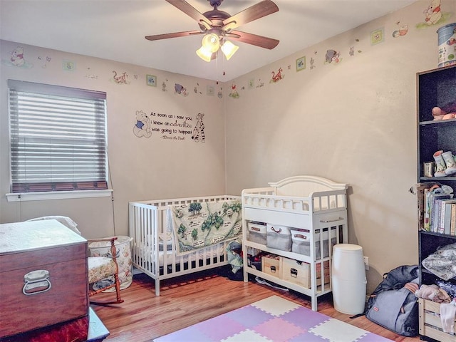 2901 Maple Ln, Edmond, OK 73034 - bedroom featuring wood finished floors, ceiling fan, and a nursery area