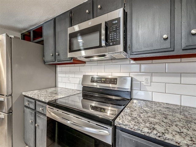6500 N Grand Blvd Unit 131, Oklahoma City, OK 73116 - kitchen with appliances with stainless steel finishes, tasteful backsplash, and a textured ceiling