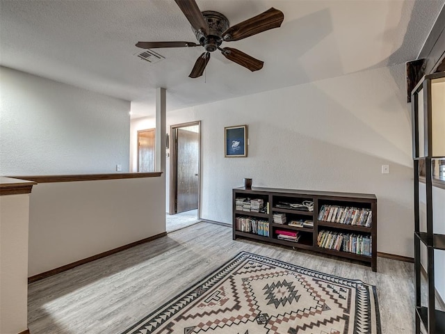 6500 N Grand Blvd Unit 131, Oklahoma City, OK 73116 - sitting room featuring wood finished floors, a ceiling fan, and a textured wall