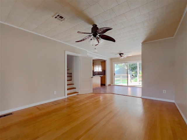 2437 NW 36th Ter, Oklahoma City, OK 73112 - unfurnished living room with ornamental molding, ceiling fan, light wood-style flooring, and stairway