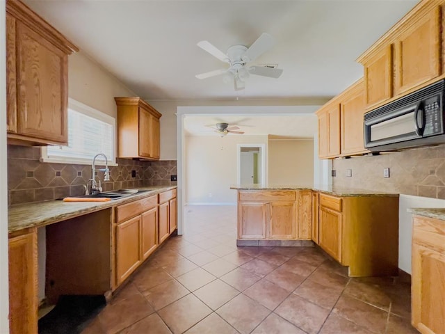 2437 NW 36th Ter, Oklahoma City, OK 73112 - kitchen with black microwave, a ceiling fan, tasteful backsplash, light stone countertops, and light tile patterned floors
