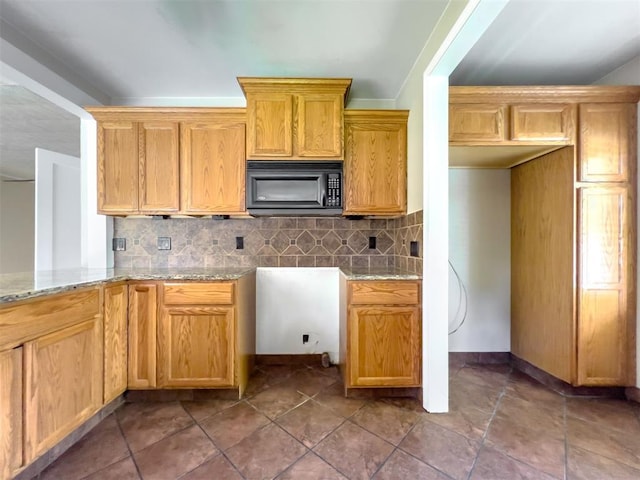 2437 NW 36th Ter, Oklahoma City, OK 73112 - kitchen featuring black microwave, decorative backsplash, and light stone counters