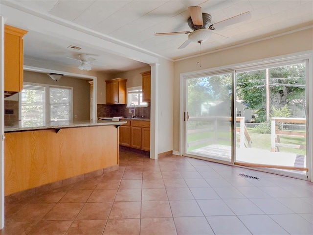 2437 NW 36th Ter, Oklahoma City, OK 73112 - kitchen with ceiling fan, plenty of natural light, tasteful backsplash, and a peninsula
