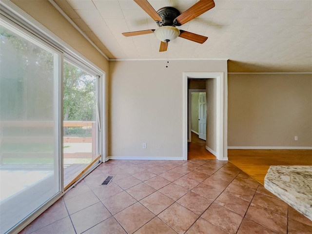 2437 NW 36th Ter, Oklahoma City, OK 73112 - spare room featuring light tile patterned floors, a ceiling fan, and ornamental molding